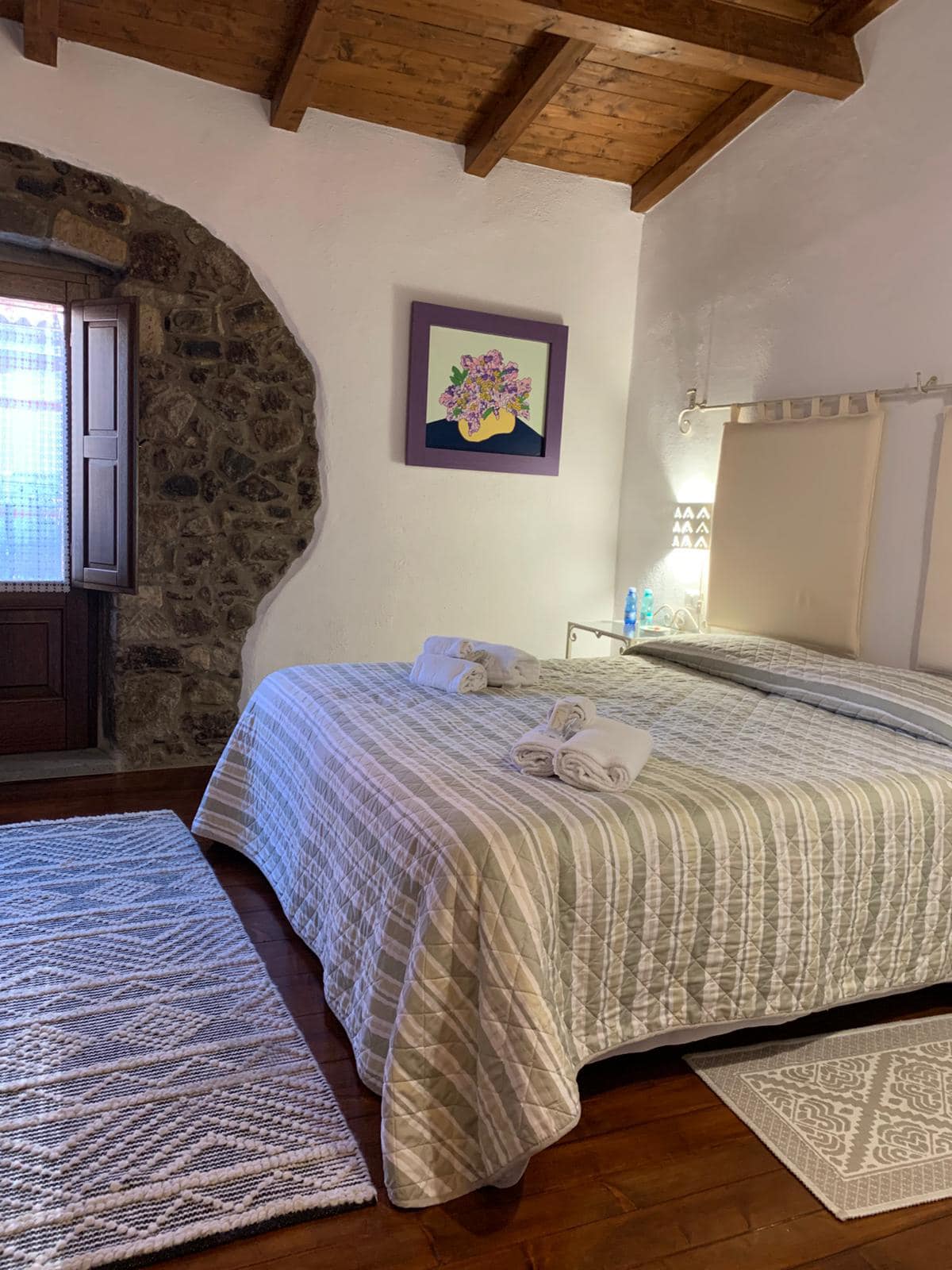 Camera 104 Monte Urtigu con letto matrimoniale e parete in pietra